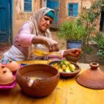 Traditional Moroccan Woman Preparing Tagine in a Village Courtyard