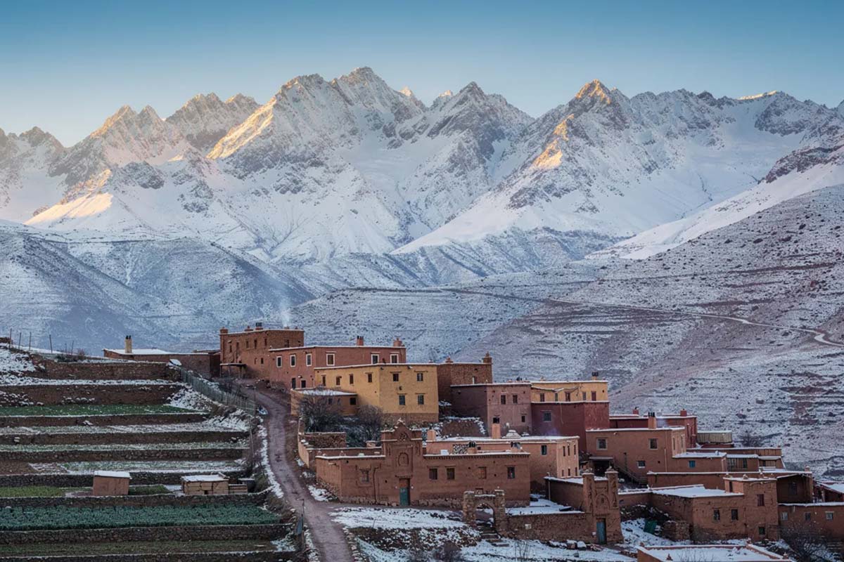 Snow-covered Atlas Mountains with Berber village and terraced fields in winter