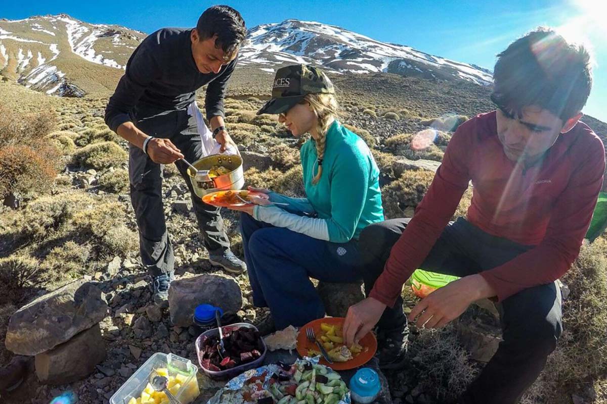 Hikers enjoying a picnic lunch during a trek in the High Atlas Mountains